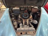 a blue car with an engine in the trunk