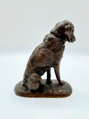 une statue représentant un chien assis sur un rocher
