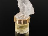 a close up of a glass bottle with a bird on top of it