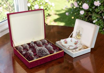 une boîte de chocolats posée sur une table, à côté d'une tasse et d'une soucoupe