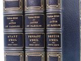 three blue books are lined up in a row on a white surface