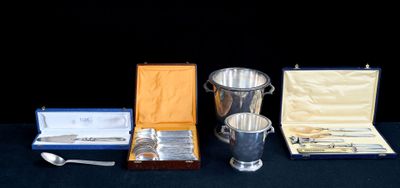une tasse en argent, une cuillère et d'autres couverts en argent posés sur une table
