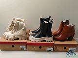 three pairs of women ' s boots are on display in a box