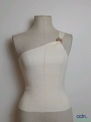 un mannequin posé sur un autre mannequin, orné d'un bouton en bois