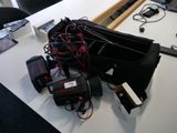 un ordinateur portable posé sur un bureau, avec tout un tas de câbles autour
