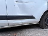 a white van that has been damaged and is parked on the side of the road