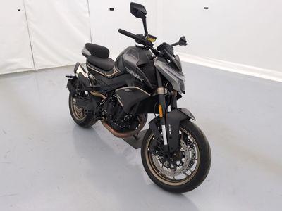 une moto noire garée dans une pièce aux murs blancs