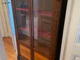 a wooden cabinet with glass doors in a room