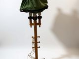 a lamp on a wooden stand with a green shade on it