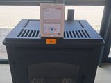 un petit poêle noir posé devant une fenêtre