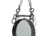 un miroir suspendu à une chaîne, entouré d'une autre chaîne