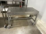 two stainless steel tables on wheels in a room