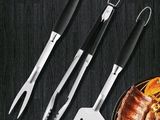 un lot de 4 ustensiles de barbecue en acier inoxydable avec des manches noirs