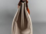 a small bag with a brown leather handle and a tan lining