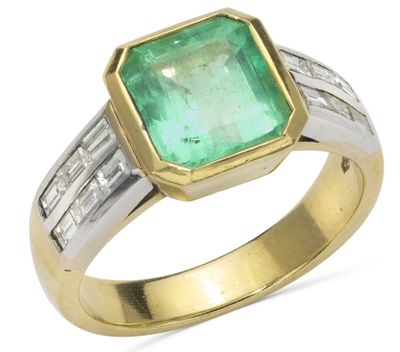 a close up of a ring with an emerald stone and diamonds