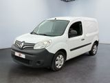 La camionnette blanche est garée dans une grande pièce au sol noir.
