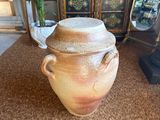 a large brown pot sitting on the floor next to a lamp