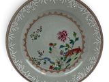 a plate with a floral design on it on a white surface