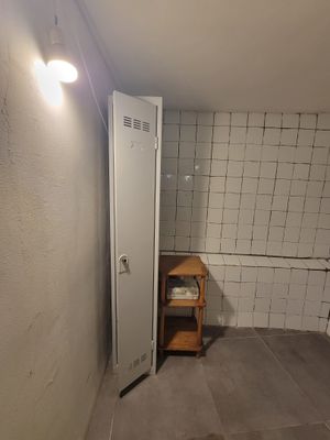 une petite salle de bains dont les murs et le sol sont carrelés de blanc