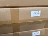 Plusieurs cartons sont empilés les uns sur les autres et portent des étiquettes.