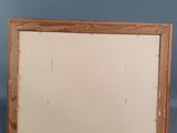 an old picture frame sitting on top of a table next to a wall