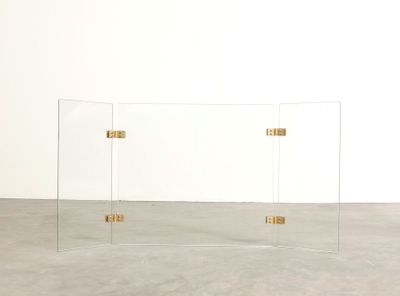 une photo d'une table en verre transparent ornée de poignées dorées