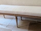 a bench with a white cushion on it in a room