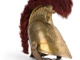 an old helmet with a red feather on top of it