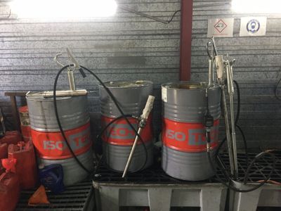 trois fûts posés sur une palette dans un garage