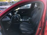 a red car with black leather seats in a parking lot