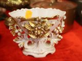 un vase blanc et doré posé sur une table rouge