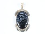une photo d'un pendentif orné d'une pierre noire et bleue
