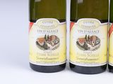 three bottles of wine sitting next to each other on a white surface