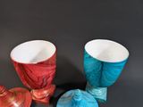 three different colored vases sitting on a black surface