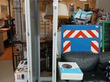 a room with a couch, a chair, a table, and a metal rack