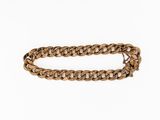 a close up of a gold chain bracelet on a white background