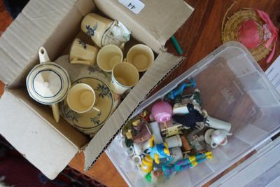 une boîte remplie de tasses et de théières posée sur une table