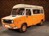 an orange and white van parked in front of a brick wall
