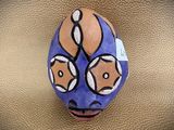 a blue and orange mask on a gold surface