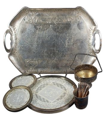 un plateau en argent sur lequel sont disposées des assiettes et des tasses en argent