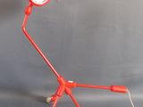 une lampe rouge posée sur un trépied
