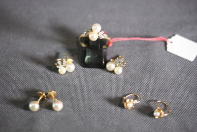 three pairs of earrings and a necklace on a table