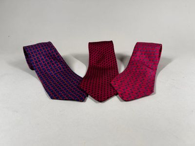three different colored ties laying next to each other on a white surface