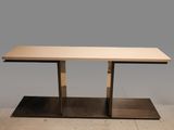 une table avec un piètement en métal et un plateau en bois