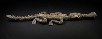 une image représentant un alligator en peluche posé sur une surface noire