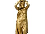 gold statue of a woman carrying a pot on her head