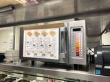 une photo de la cuisine d'un restaurant avec un menu accroché au mur