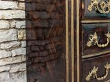 a brown chest of drawers with gold decorations on it