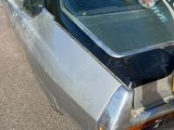 une voiture argentée avec une planche de surf sur le toit