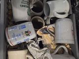a bin full of coffee cups and mugs on the floor